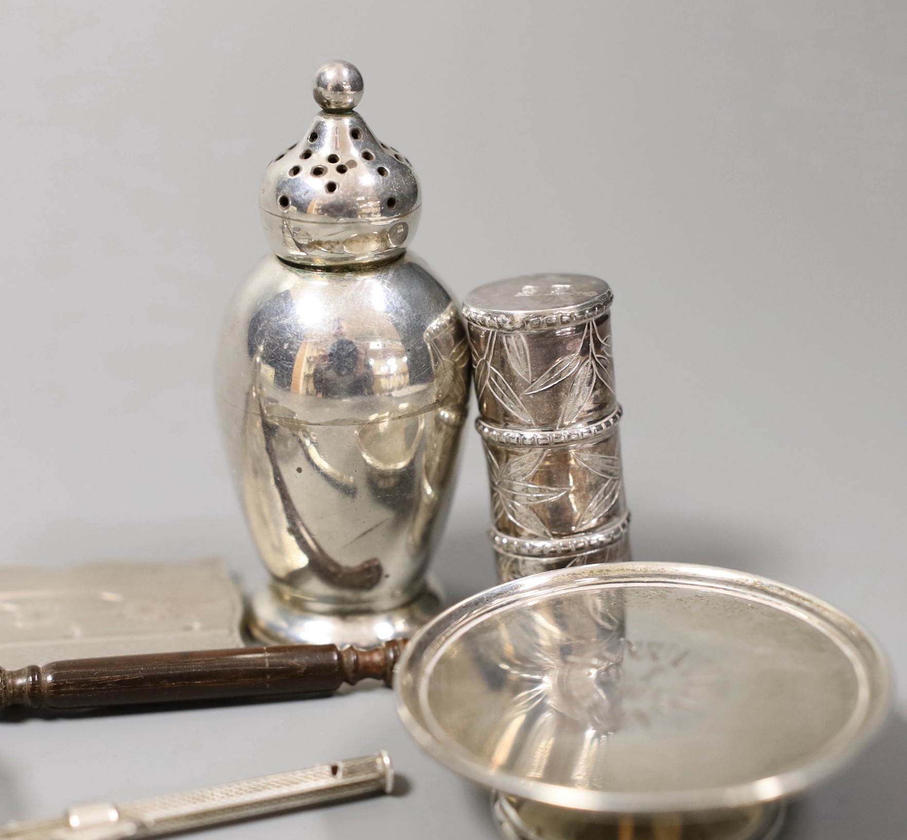 A quantity of small silver or white metal items including a long handled server spoon, Chinese pepperette, pair of Victorian pepperettes, Victorian silver paten, 19th century toddy ladle by Taylor & Perry, folding comb,